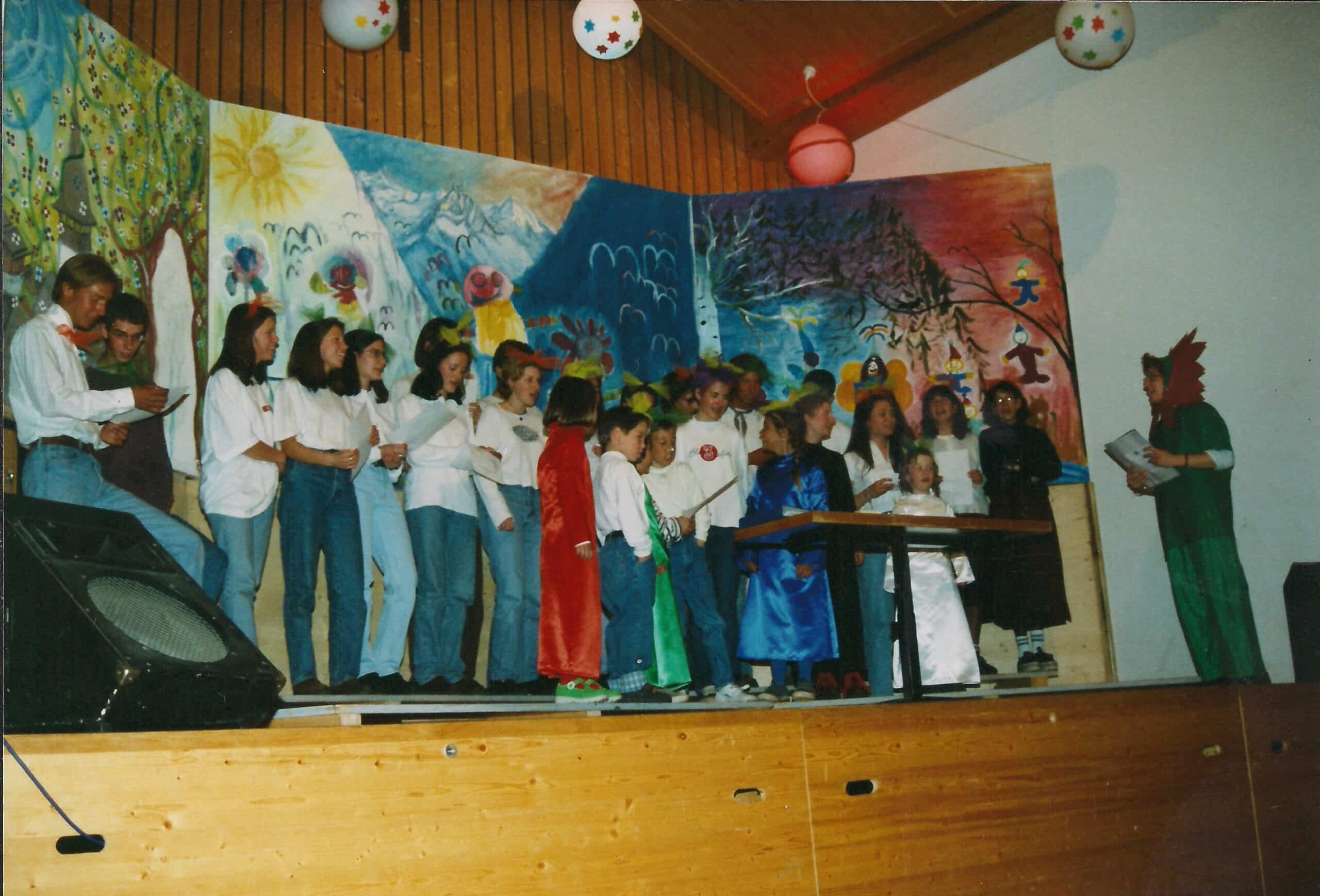 Un groupe d'enfants et d'adolescents en spectacle sur scène.