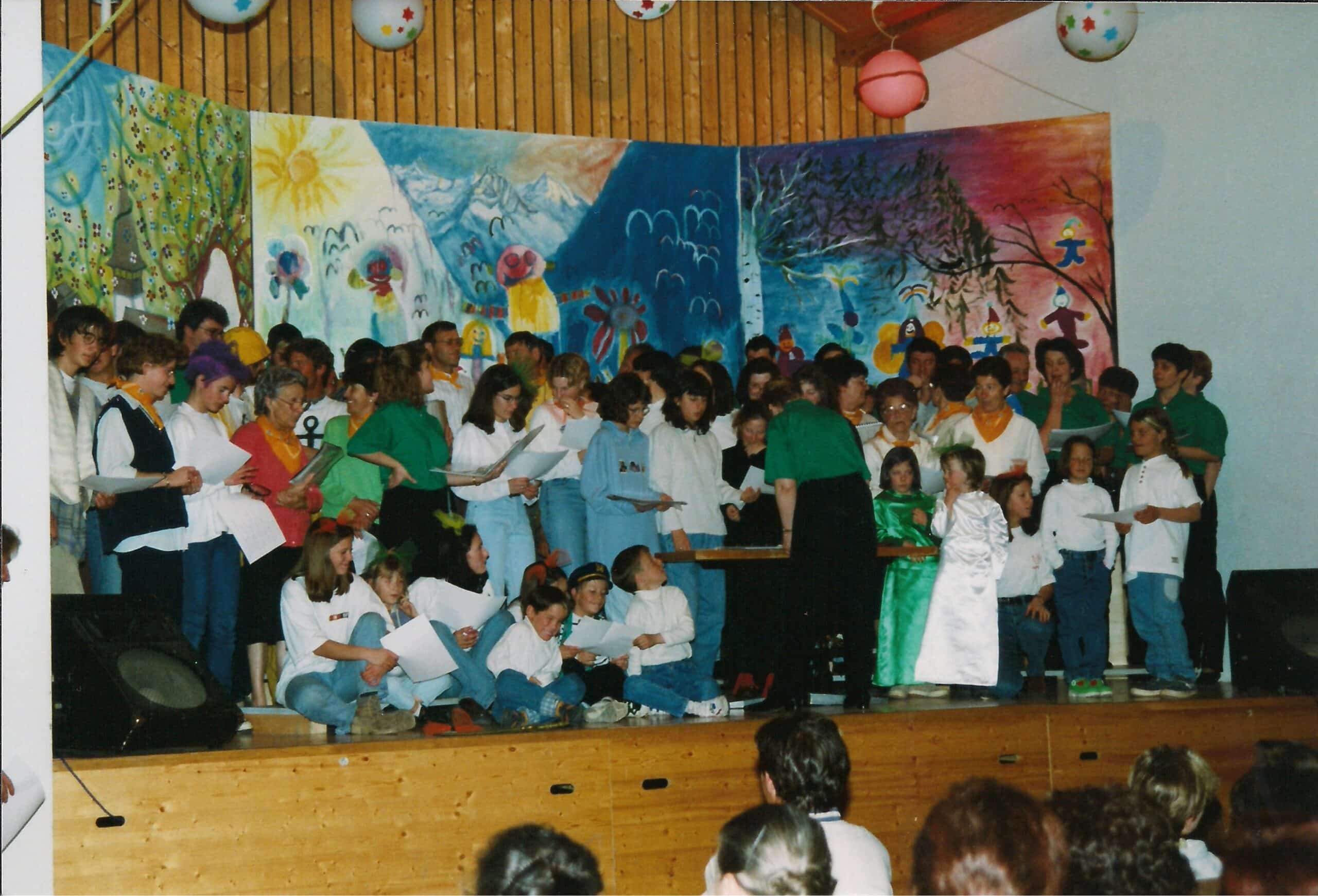 Un groupe d'enfants et d'adolescents chantant sur une scène.