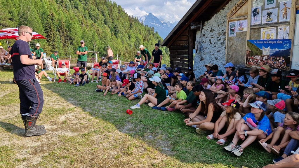 Un pompier s'adressant à des enfants dans un camp de montagne.