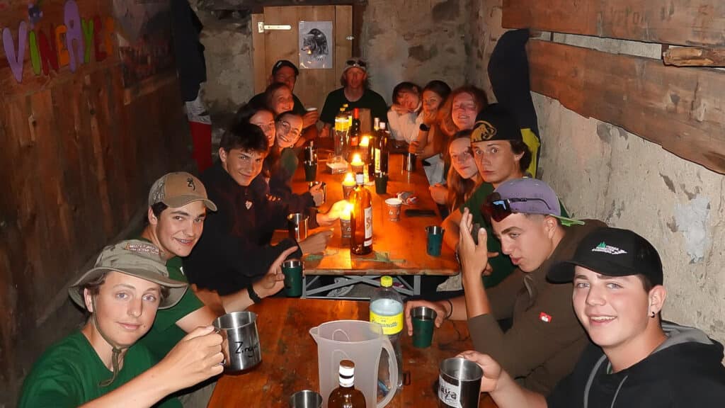 Groupe de jeunes attablés à la lueur des bougies.