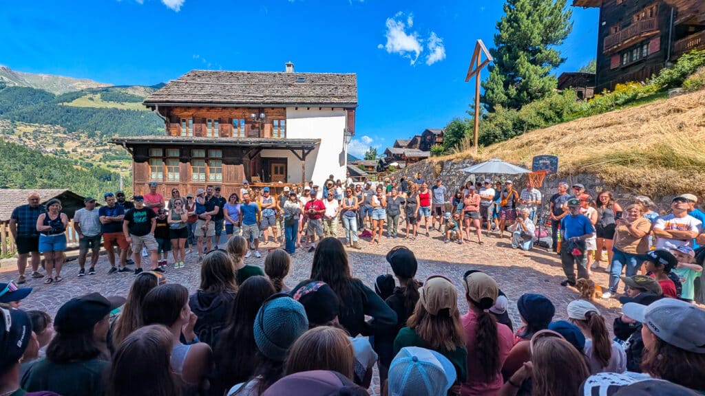 Foule de personnes rassemblée sur la place d'un village montagnard.
